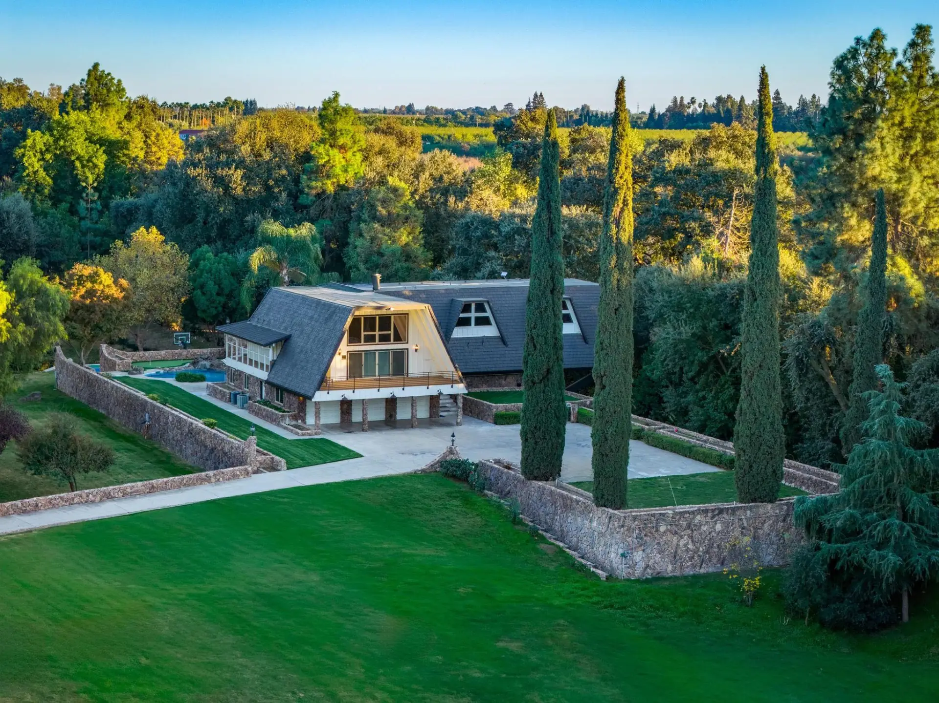 Grand Waterside Estate — aerial view of pool and grounds at twilight